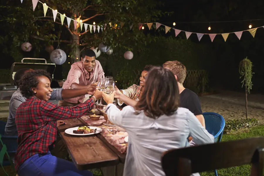 Friends and family making a toast at an outdoor dinner party